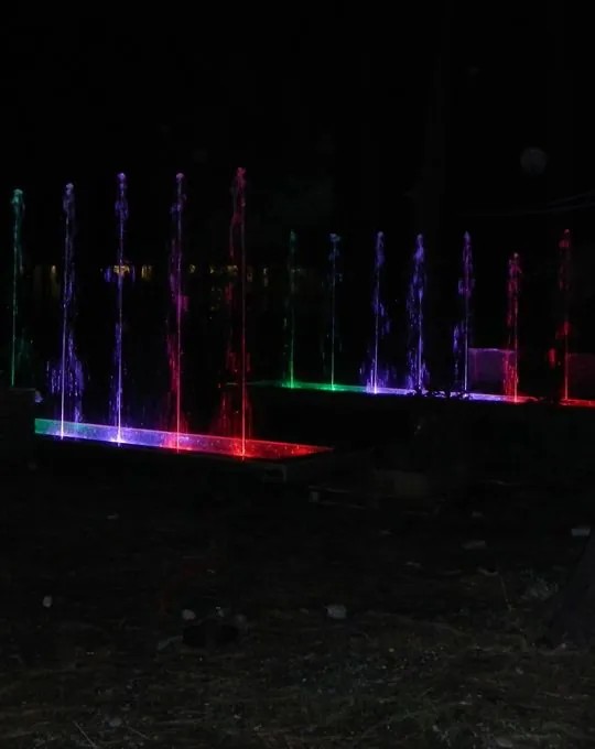 Getti d'acqua colorati di una fontana dinamica in notturna