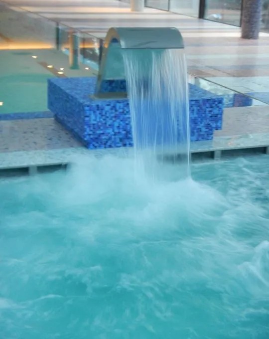 Cascata d'acqua in vasca rivestita di mosaico blu